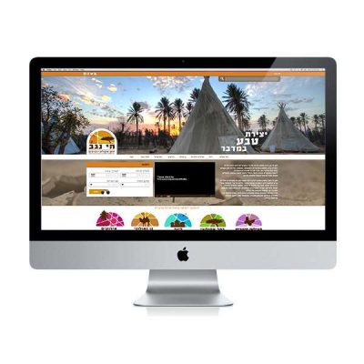 עיצוב אתר – דף הבית של חי נגב על מסך iMac, אוהלי טיפי ודקלים בשקיעה והכיתוב יצירת טבע במדבר | פורטפוליו קרנף סטודיו