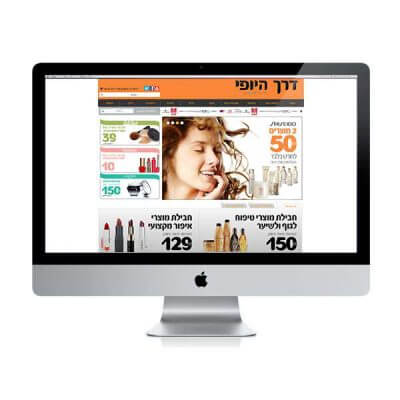 עיצוב אתר – אתר רשת הקוסמטיקה דרך היופי על מסך iMac, באנר כתום, דוגמנית ומבצעי מוצרי טיפוח | פורטפוליו קרנף סטודיו